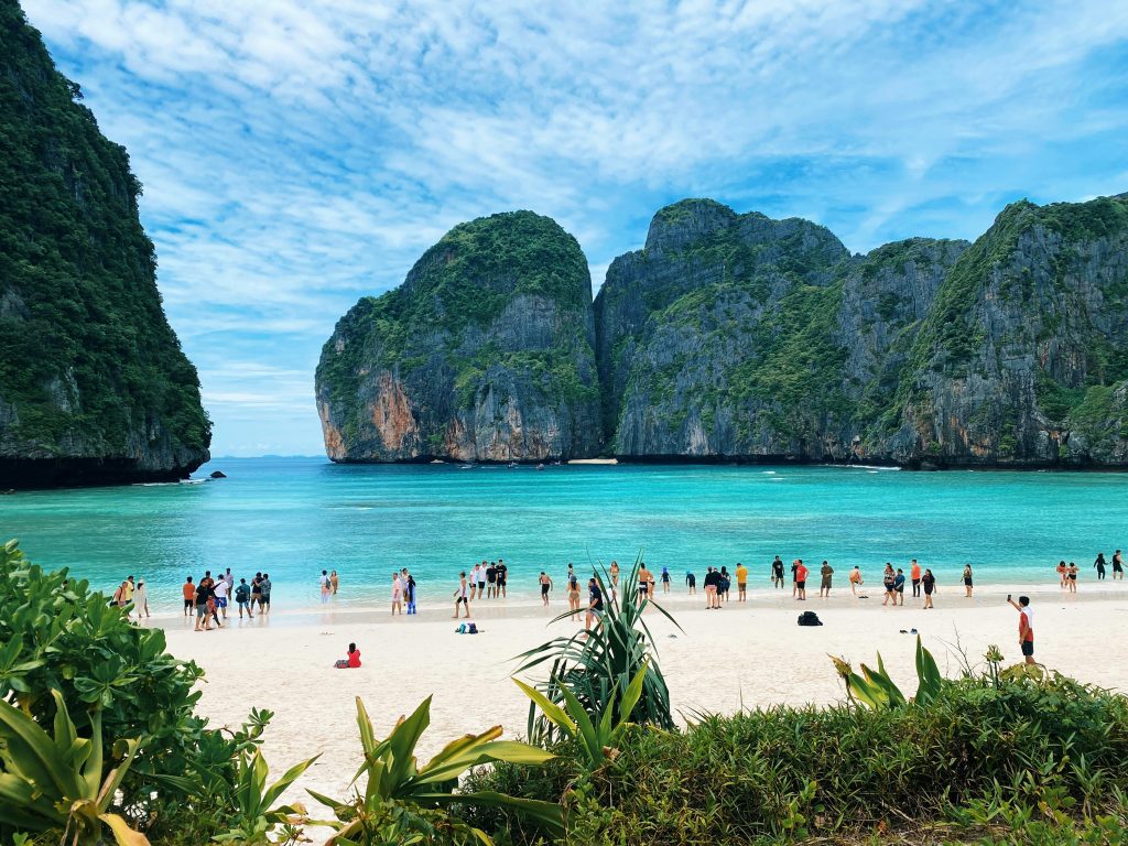 a group of people standing on top of a sandy beach