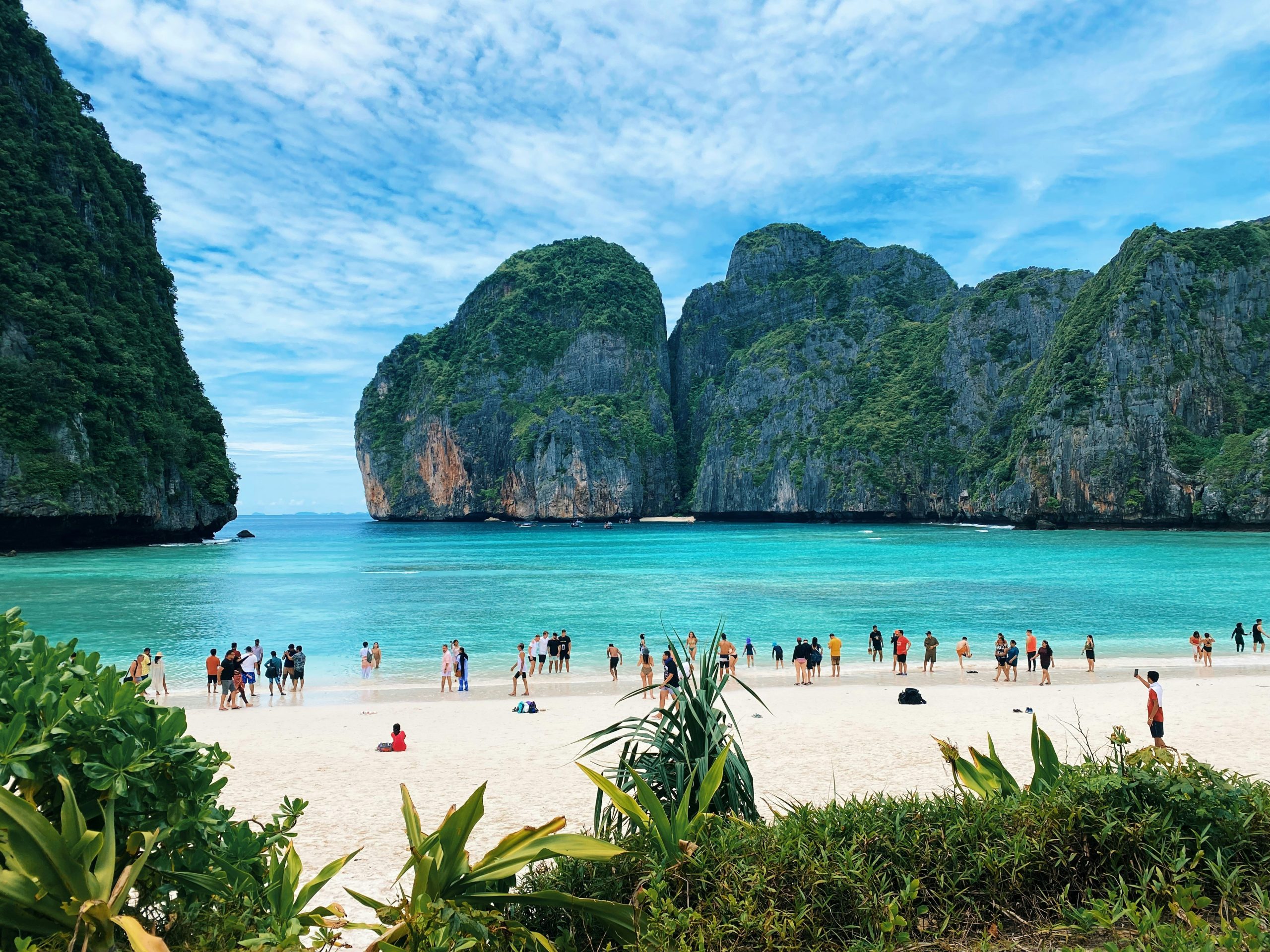 a group of people standing on top of a sandy beach