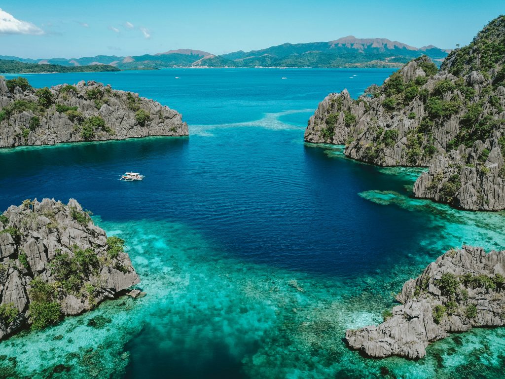 aerial photo of clear blue sea surrounded by mountains