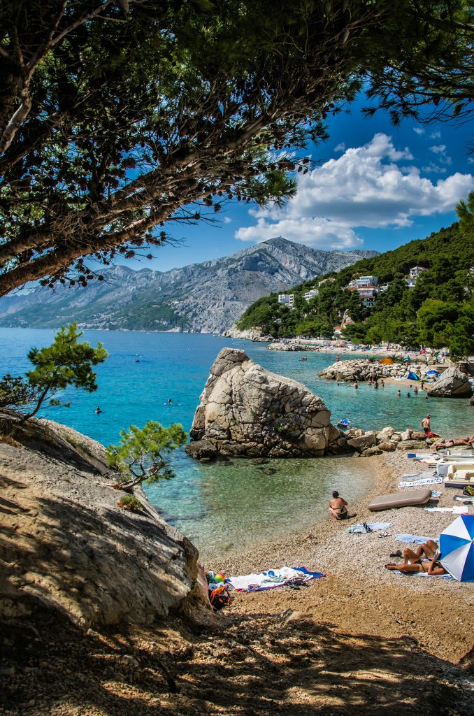 a beach with people laying on the sand and umbrellas