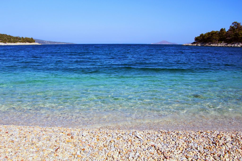 a body of water sitting next to a sandy beach