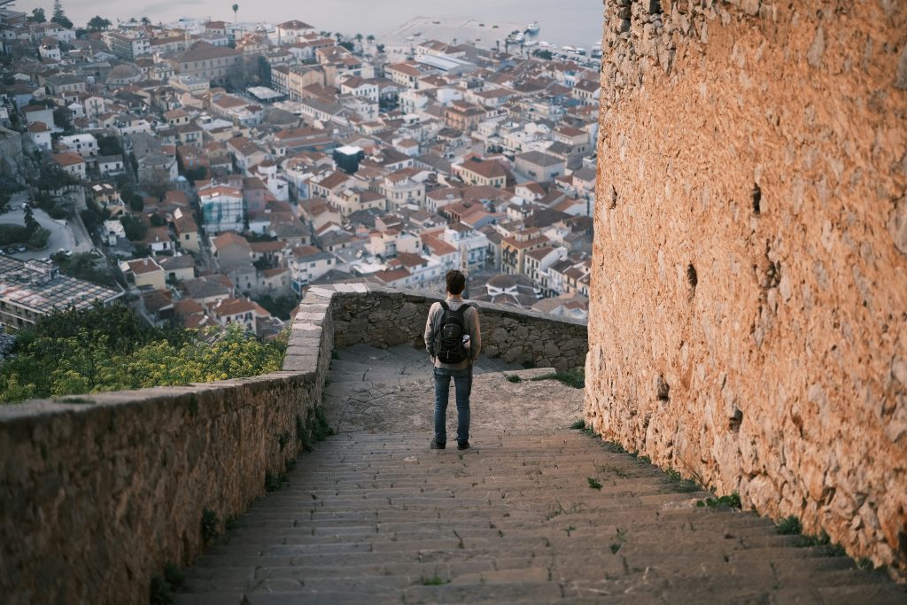 a person standing on a stone wall with a city in the background