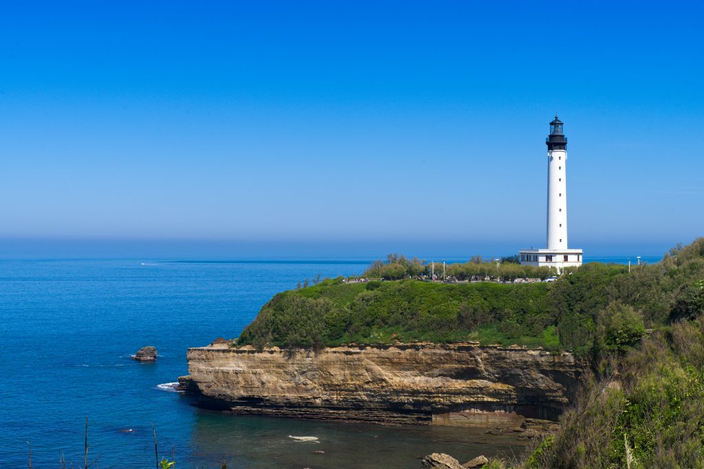 A light house sitting on top of a cliff next to the ocean