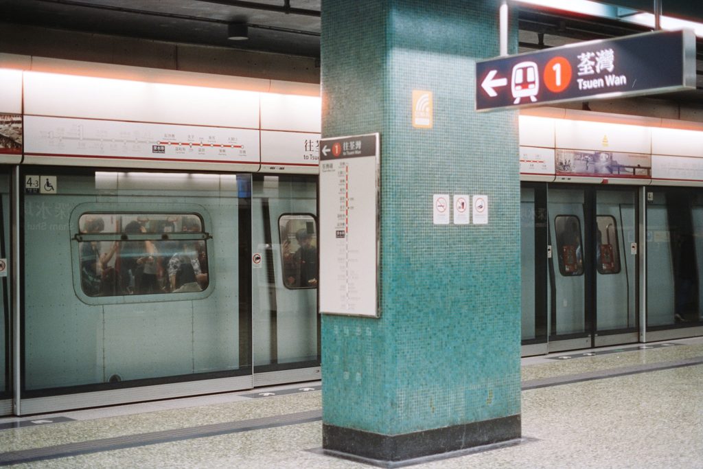 Subway train stopped at a station platform with signage.