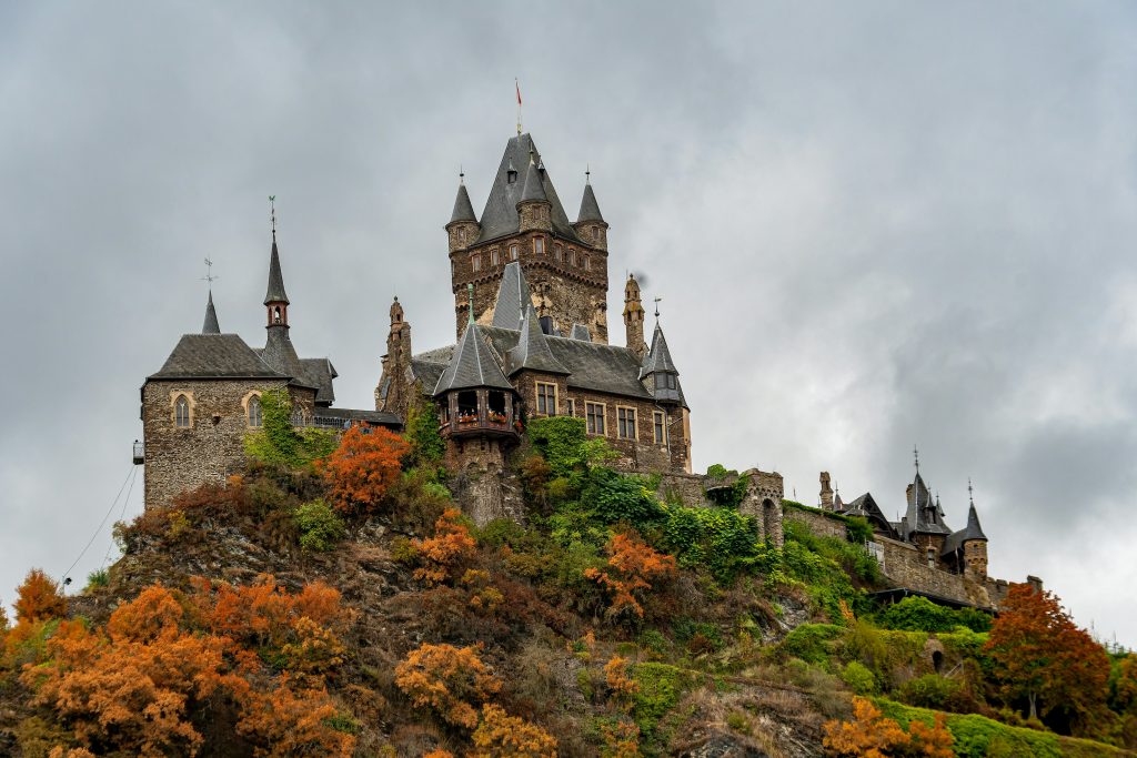 a castle on top of a hill surrounded by trees
