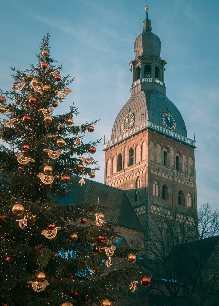 a large christmas tree in front of a church