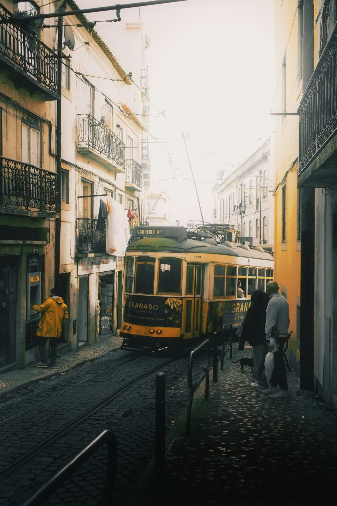 a yellow and black trolley on a city street