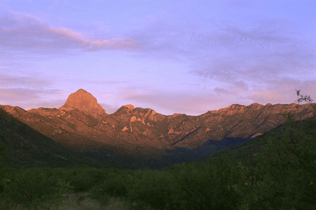 a group of people standing on top of a sandy beach